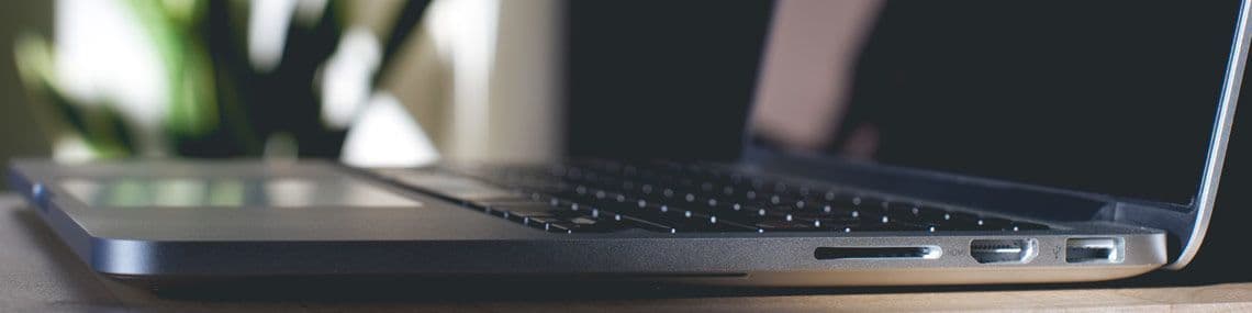 Man looking at white board with sticky notes on it, with a pen in his hand